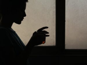 Holding a tumbler glass of whiskey
